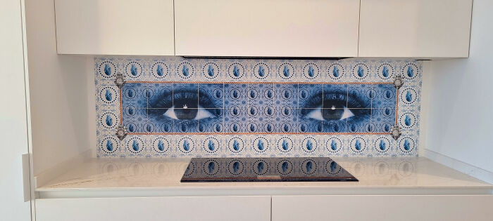 Decorative tile works with blue eyes artwork as kitchen backsplash