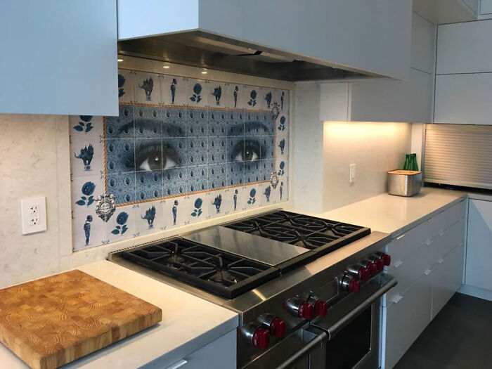 Decorative tile works with blue eyes artwork as kitchen backsplash