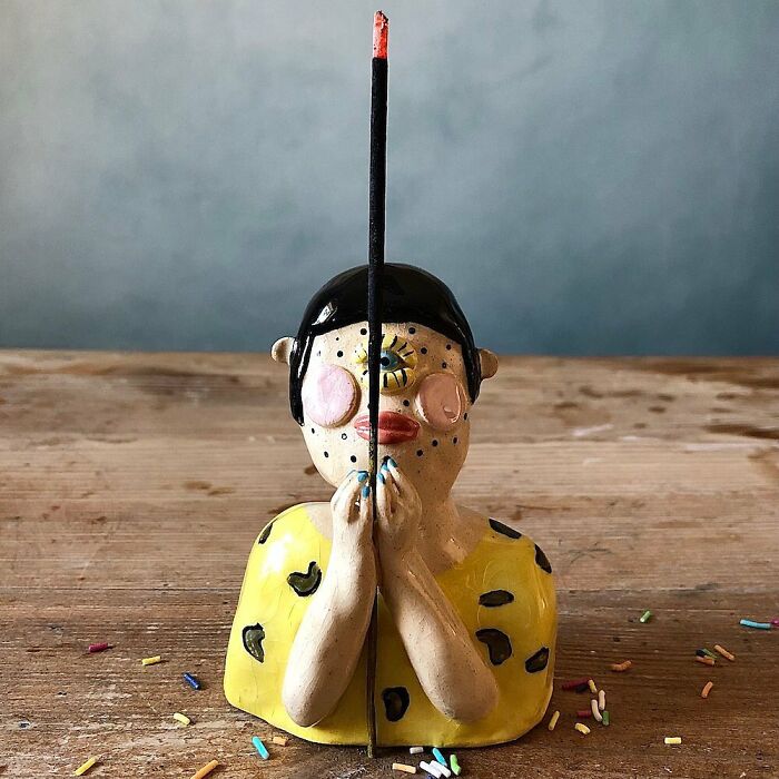 A creative incense burner designed as a weird ceramic sculpture of a person, adding character to home decor.