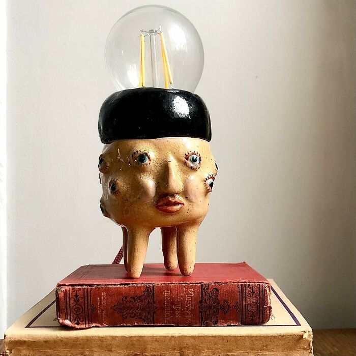 An unusual face-shaped lamp that acts as a weird ceramic sculpture, bringing unique style to home decor.