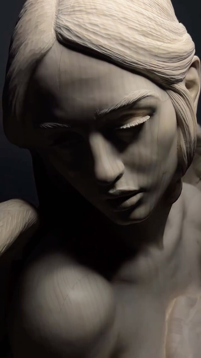 Close-up of a lifelike sculpture of a woman's face showing detailed wood grain