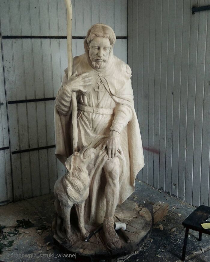 Lifelike wood sculpture of a saint with a staff and dog by a Polish artist