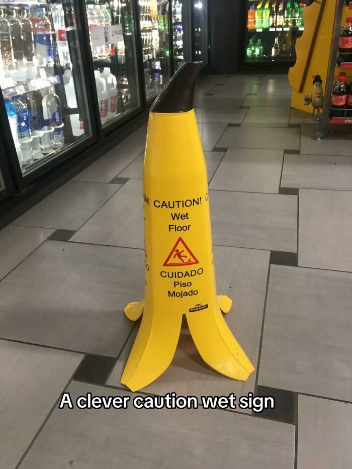 Yellow banana-shaped caution wet floor sign in a store aisle