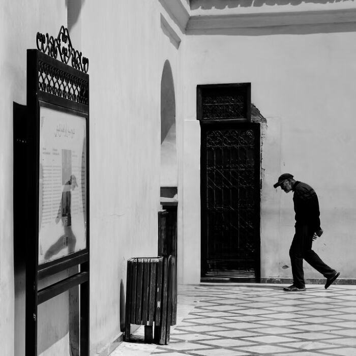 Remarkable travel photos of a man walking past an ornate display in a gallery, showcasing a unique place.