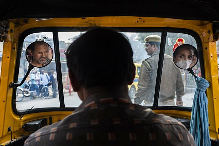 A candid street photo inside a taxi showing a driver and passengers reflected in the mirrors for the URBAN Photo Awards.