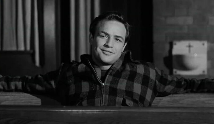 Marlon Brando in a plaid jacket, smiling, an iconic moment that has nothing to do with flight attendants rolling their eyes.