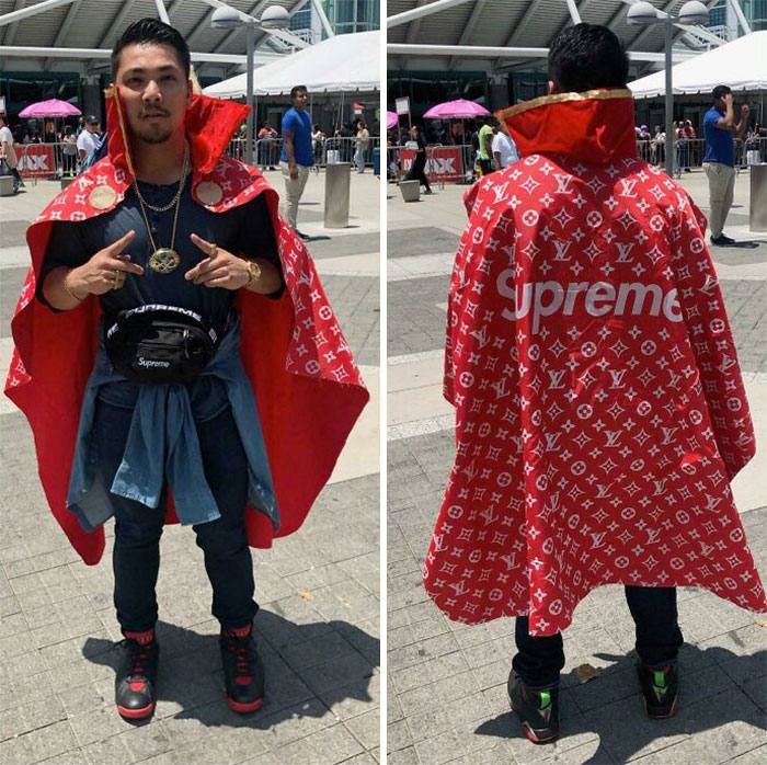 Man wearing red Supreme Louis Vuitton cape showing front and back design