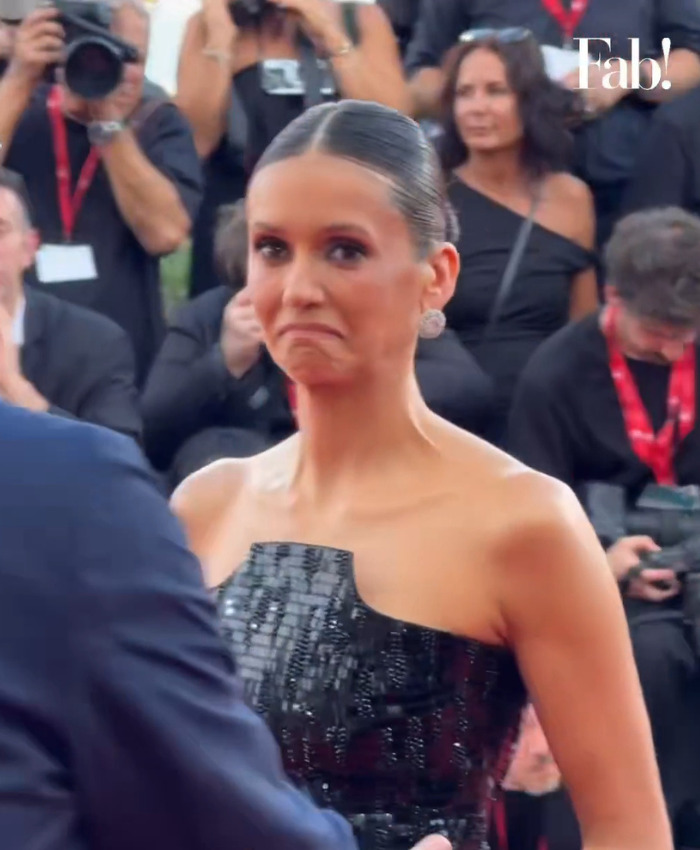 Nina Dobrev looking upset after a security guard forces her out of the Venice Film Festival red carpet. Nina Dobrev looking upset after a security guard forces her out of the Venice Film Festival red carpet.
