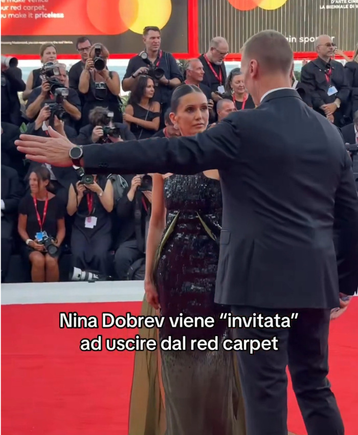 Nina Dobrev being forced out by a security guard from the Venice Film Festival red carpet, a moment captured by many. Nina Dobrev being forced out by a security guard from the Venice Film Festival red carpet, a moment captured by many.