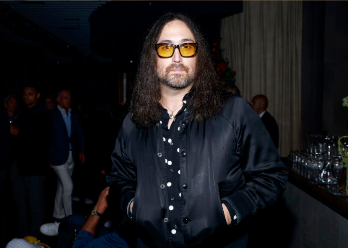 Sean Ono Lennon, John Lennon's grandson, with long hair and sunglasses at an event. Sean Ono Lennon, John Lennon's grandson, with long hair and sunglasses at an event.
