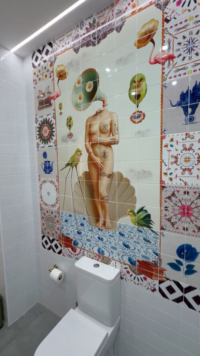 Artistic tile works mural with surreal figure and birds in bathroom above toilet