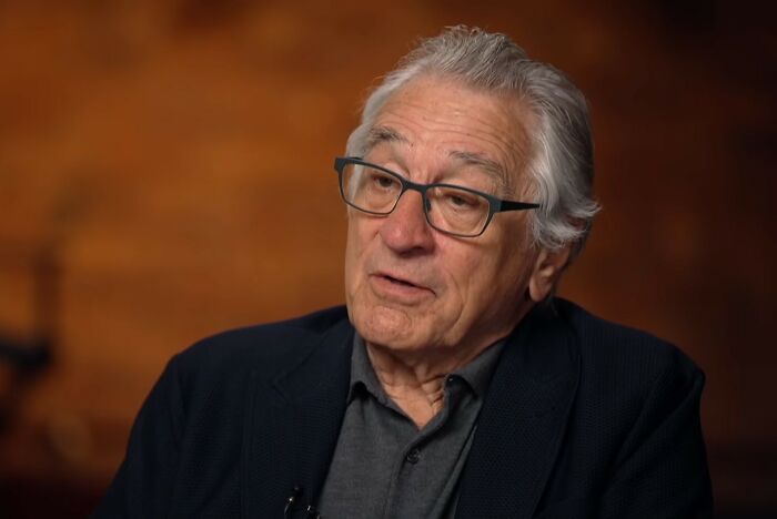 A man wearing glasses, looking thoughtful, like a lawyer contemplating a client's stupid actions.