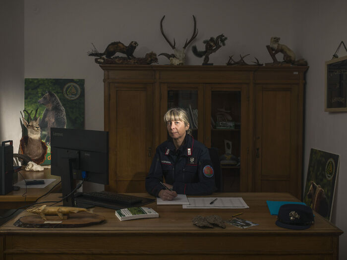 Photographer's project capturing a woman in a bureaucratic office, surrounded by taxidermy and official documents.