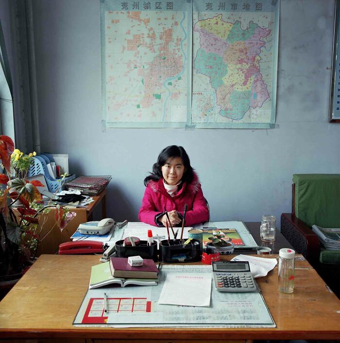 Photographer's project featuring a young woman in a bureaucracy office with maps on the wall, documenting people.