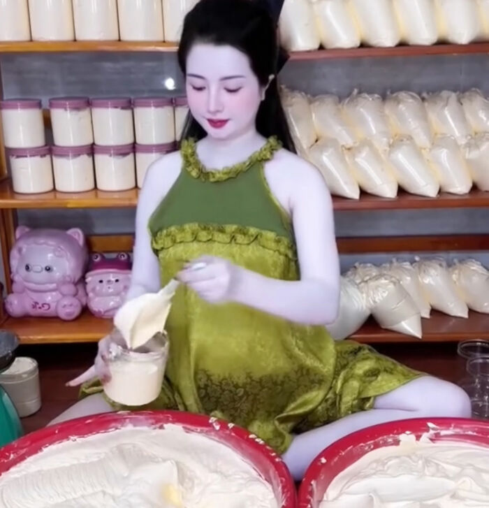 Woman in green applying a beauty product, surrounded by jars and bags, part of a wedding day transformation. Woman in green applying a beauty product, surrounded by jars and bags, part of a wedding day transformation.
