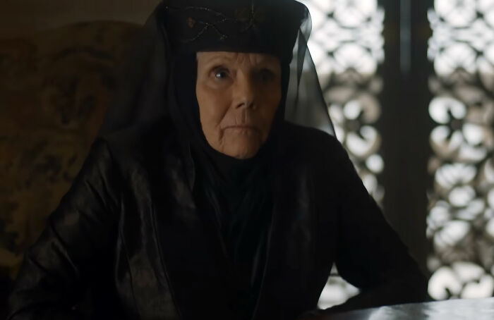 A Game of Thrones icon, an older woman in a black gown and headpiece, looking intently.