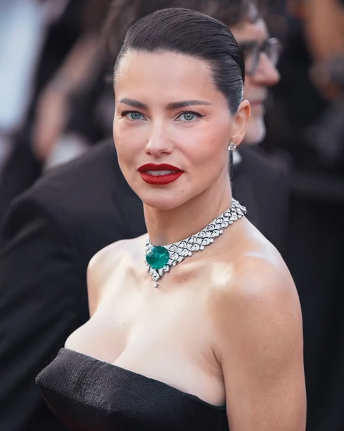 A close-up photo of supermodel Adriana Lima, showcasing her viral transformation with a sleek hairstyle and red lipstick