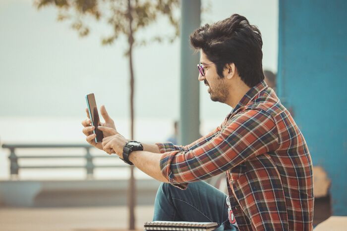 A client taking a selfie, oblivious, showcasing lawyers shocked by stupid clients.