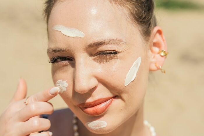 A woman winking, applying cream to her face, a stupid thing people said without realizing how ridiculous they sounded.