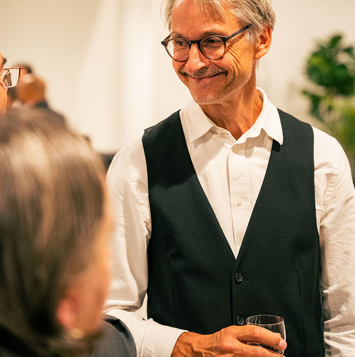 Smiling older man holding glass in social setting on recognizing drinking problem Smiling older man holding glass in social setting on recognizing drinking problem