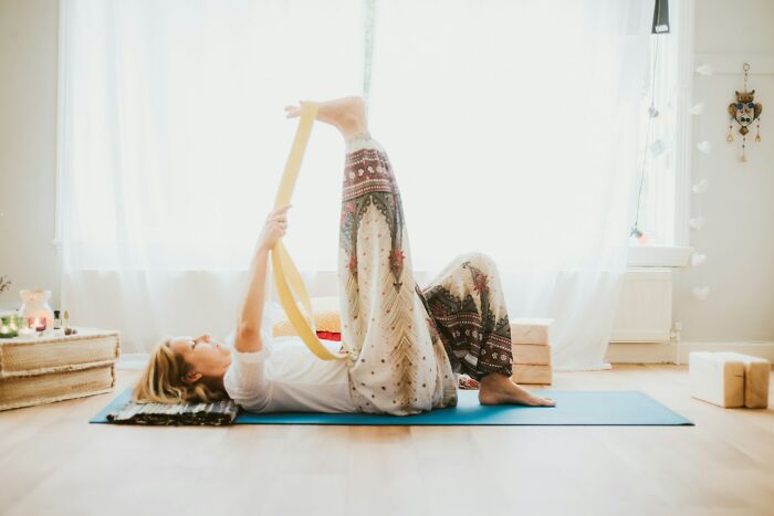 A woman in her 30s or 40s doing yoga on a mat, experiencing weird body changes like flexibility shifts.