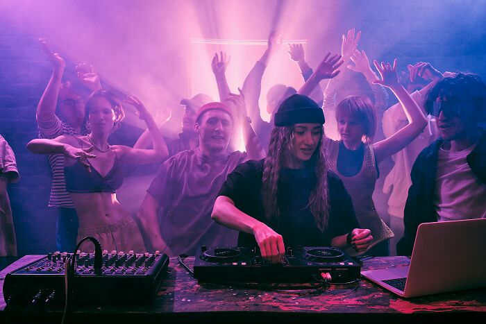 A DJ performing for a crowd in a club, symbolizing surprising things wealthy people buy for entertainment.