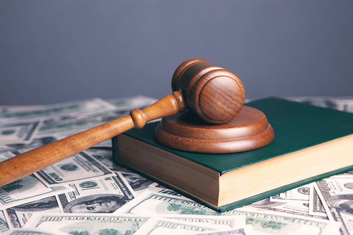 A gavel and money represent the legal outcome of the lawsuit regarding the keyed car incident.