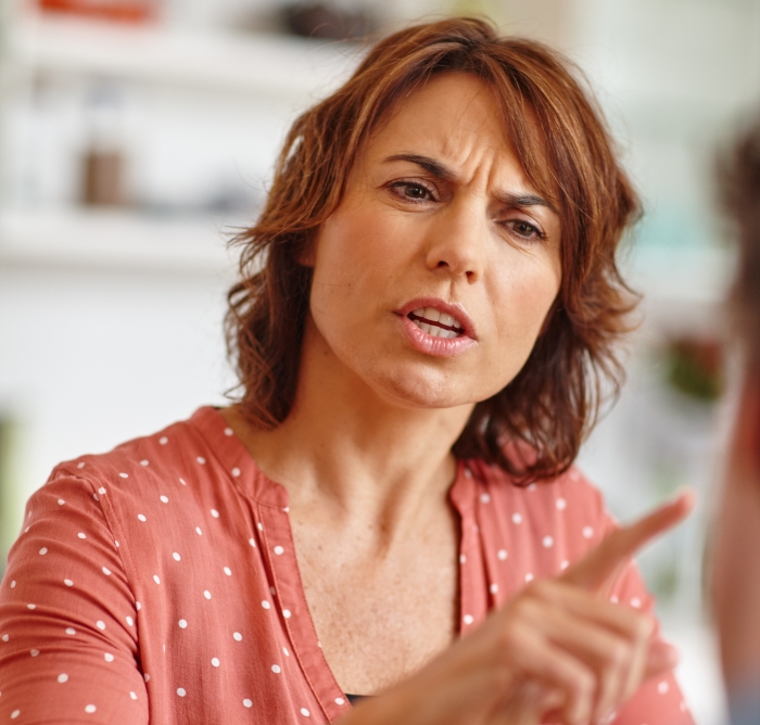 Angry woman pointing and arguing indoors