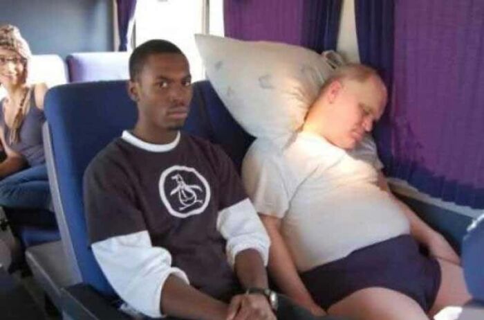 Man sleeping uncomfortably close to a passenger on public transport bus