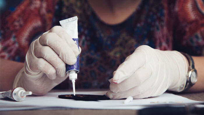 A person wearing white gloves applying glue to a small object, illustrating everyday inconveniences.