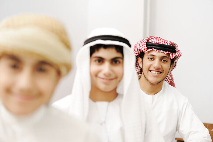 Group of smiling young men wearing traditional Middle Eastern clothing