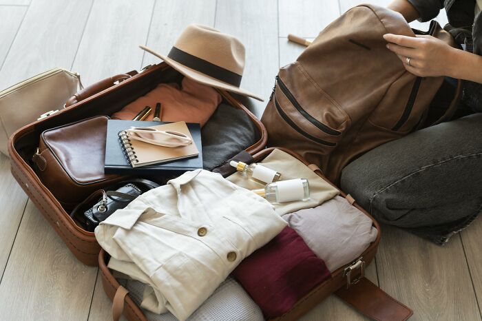 A person packing clothing into a suitcase, showcasing a new life for divorced people