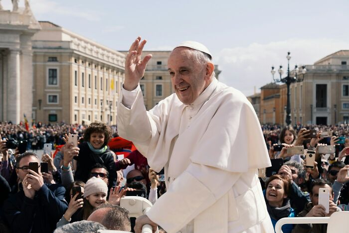 Pope waving to a crowd, oblivious to the stupid things people said without realizing their ridiculousness.