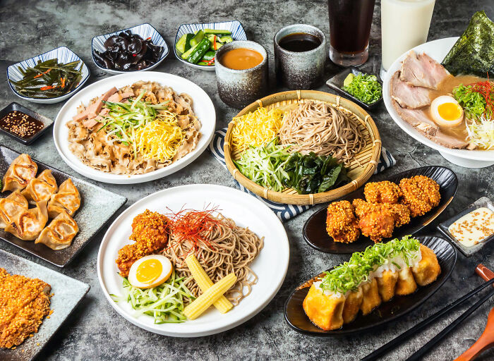 A lavish spread of various Japanese dishes, showcasing diverse culinary experiences wealthy people buy.
