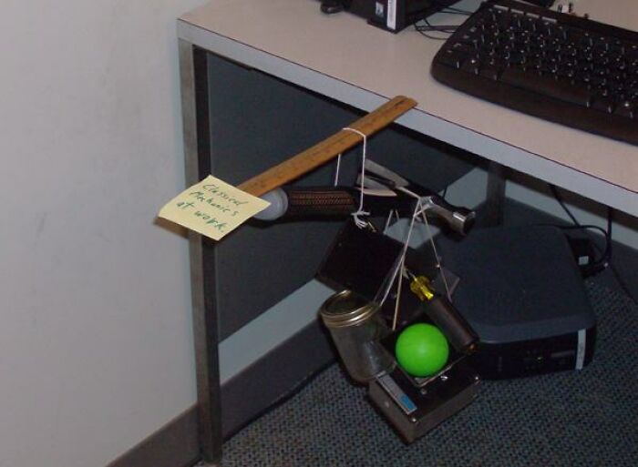 A baffling image showing a ruler suspending several items with string from a desk, seemingly defying physical sense.