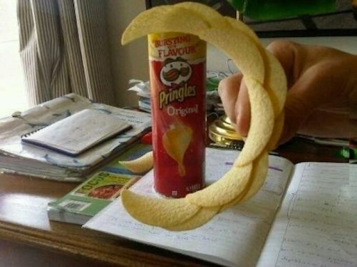 A baffling image of Pringles chips stacked in a perfect circle around the Pringles can, defying physical sense.