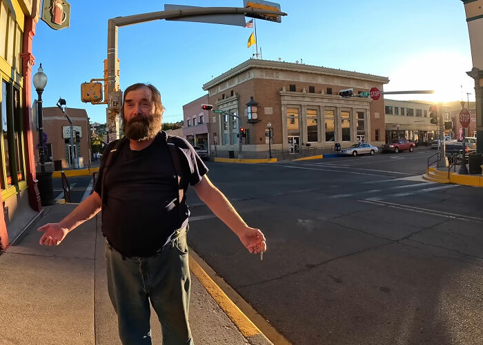 A man gesturing in the street in New Mexico, with a building and clear sky in the background, relating to the name change. A man gesturing in the street in New Mexico, with a building and clear sky in the background, relating to the name change.