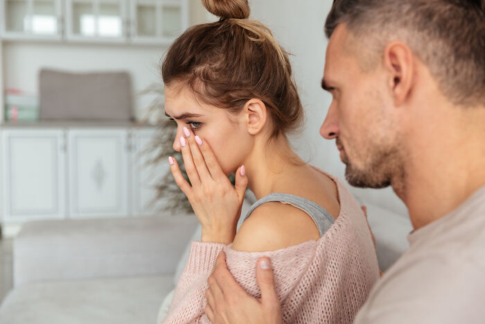 A concerned man comforting a crying woman, showing the emotional impact of subtle sexism