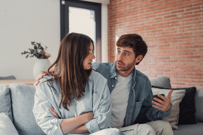 A couple having a serious discussion on the couch, reflecting on marriage and what they wish they knew before divorce.
