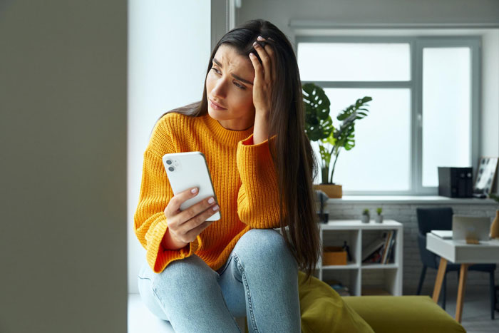 A woman looking at her phone, showing frustration for a 'love' confession from groom's bestie. A woman looking at her phone, showing frustration for a 'love' confession from groom's bestie.