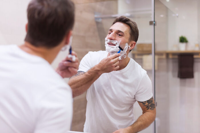 A man shaves in the mirror, representing the serious medical issues professionals treated that started innocently.