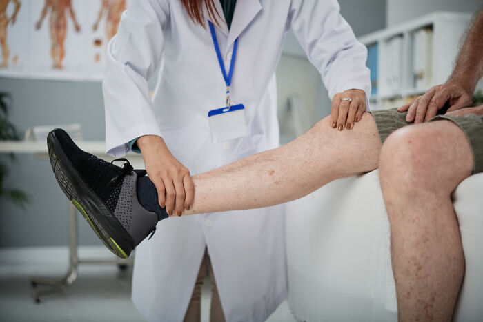 A medical professional examines a patient's leg, emphasizing treatment for serious medical issues that began subtly.