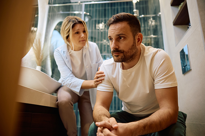 A concerned woman comforting her stressed partner in the bathroom before a family Thanksgiving A concerned woman comforting her stressed partner in the bathroom before a family Thanksgiving