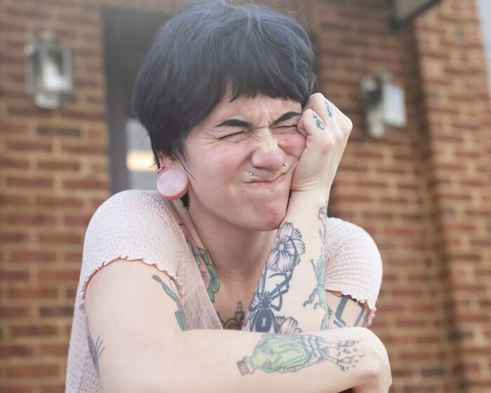 A person with tattoos making a face, demonstrating things people do that others judge them for.