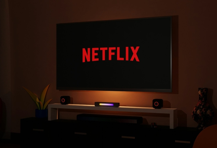 A glowing TV screen with the Netflix logo in a dimly lit room representing Netflix and Stranger Things homework A glowing TV screen with the Netflix logo in a dimly lit room representing Netflix and Stranger Things homework