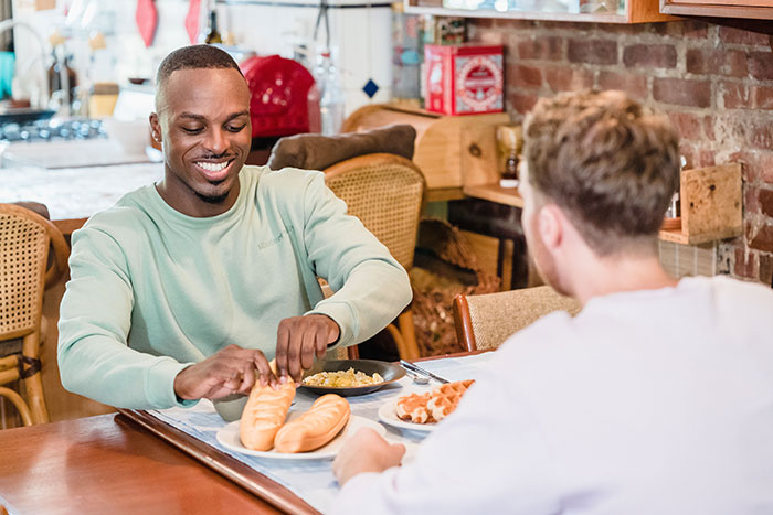 Man smiles, eating breakfast with his BIL, who secretly pays and later blames him for ordering expensive food. Man smiles, eating breakfast with his BIL, who secretly pays and later blames him for ordering expensive food.