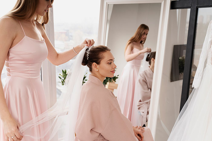 A bride getting ready for her wedding with a bridesmaid, reflecting the wedding conflict. A bride getting ready for her wedding with a bridesmaid, reflecting the wedding conflict.