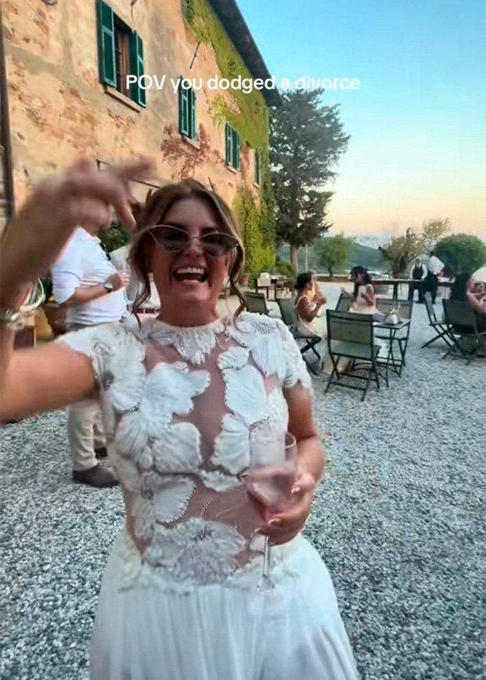 A joyful bride in a white wedding dress with a drink, celebrating at her destination wedding, now an independent woman. A joyful bride in a white wedding dress with a drink, celebrating at her destination wedding, now an independent woman.