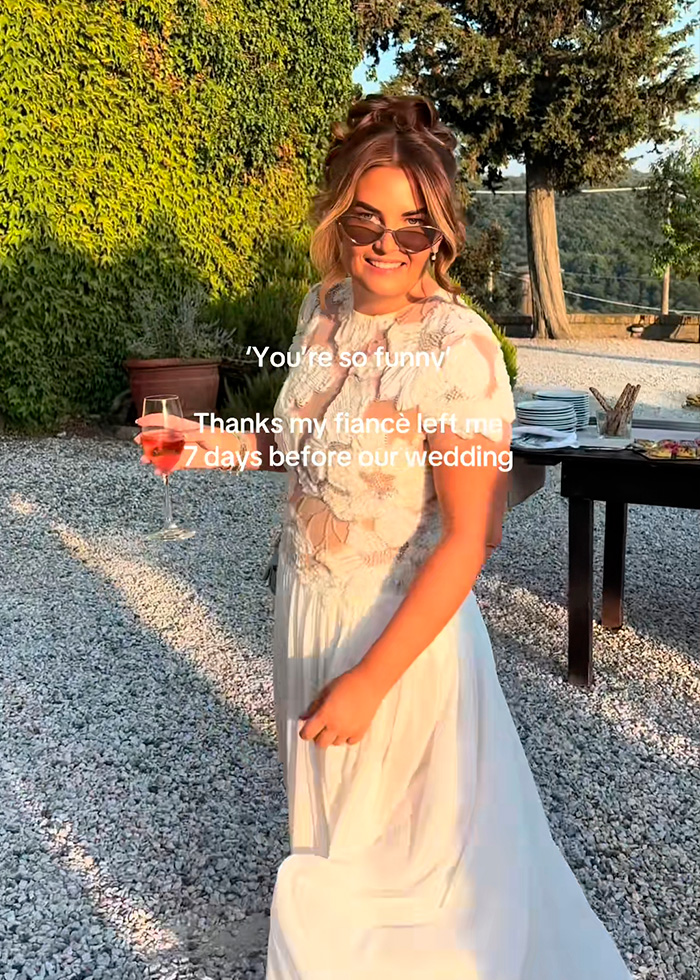 A smiling bride in a white wedding dress with a drink in hand at her outdoor destination wedding, abandoned a week prior. A smiling bride in a white wedding dress with a drink in hand at her outdoor destination wedding, abandoned a week prior.