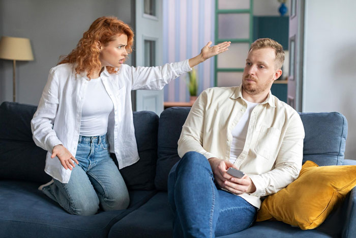 Couple arguing on couch about movie Obsession and misunderstanding